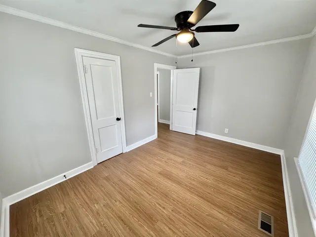 a view of empty room with wooden floor