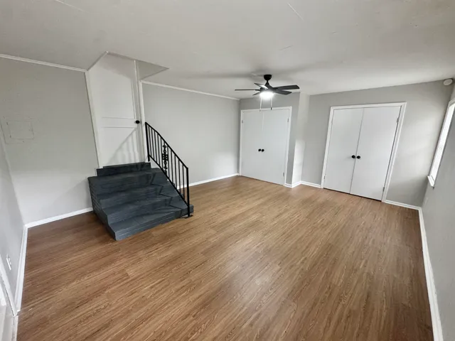 a view of a livingroom with wooden floor and staircase