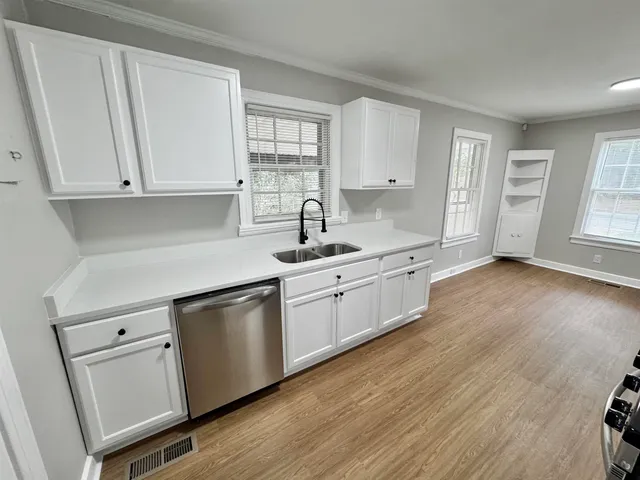 a kitchen with granite countertop white cabinets and white appliances