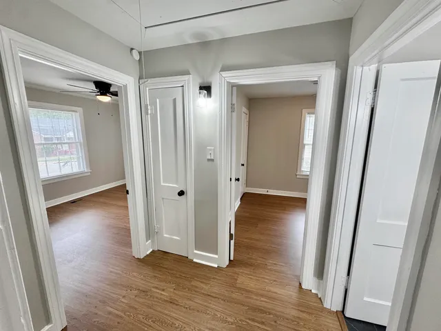 a view of a hallway with wooden floor and closet area