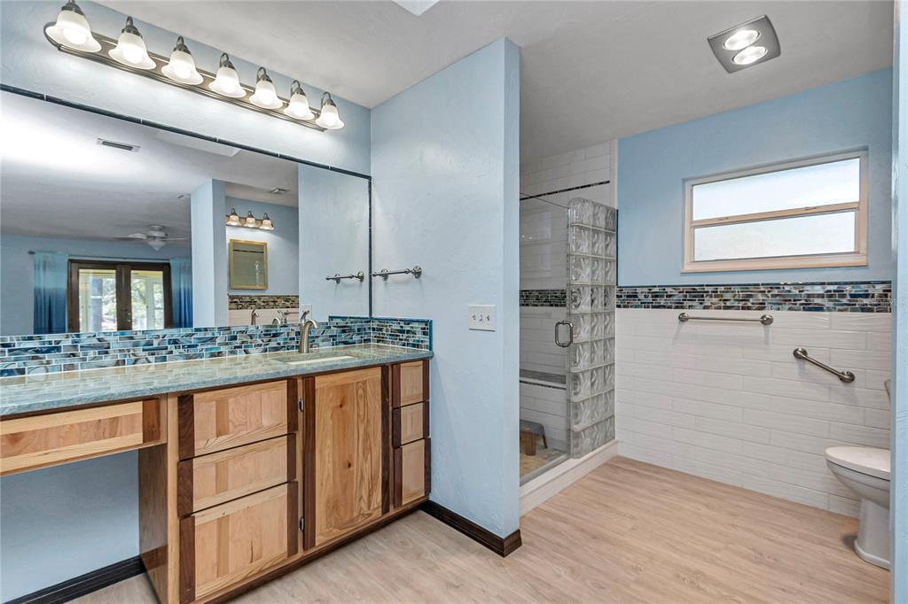 18012 Southwest 68th Loop Dunnellon, FL 34432 - Photo 24 of 60 a bathroom with a granite countertop sink a toilet a mirror and vanity