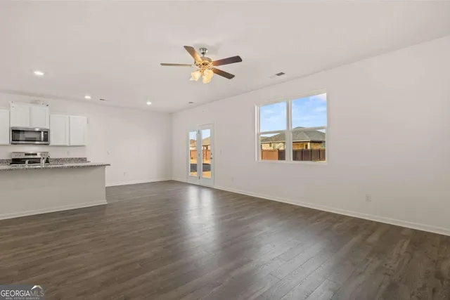 an empty room with wooden floor and sliding door