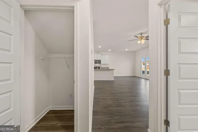 a view of a hallway with wooden floor and staircase