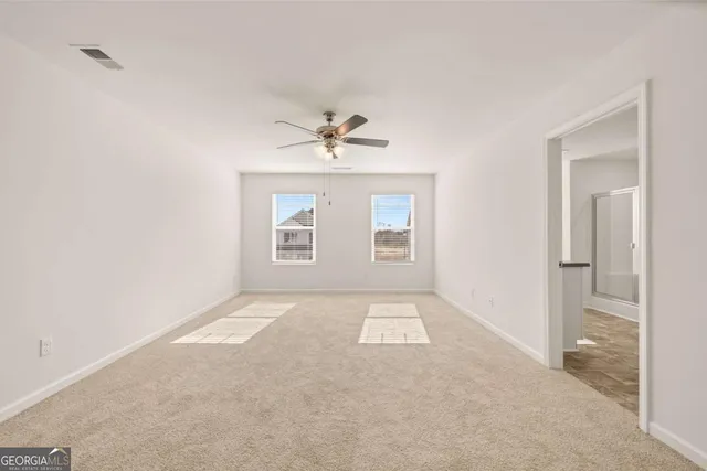 a view of an empty room with a ceiling fan