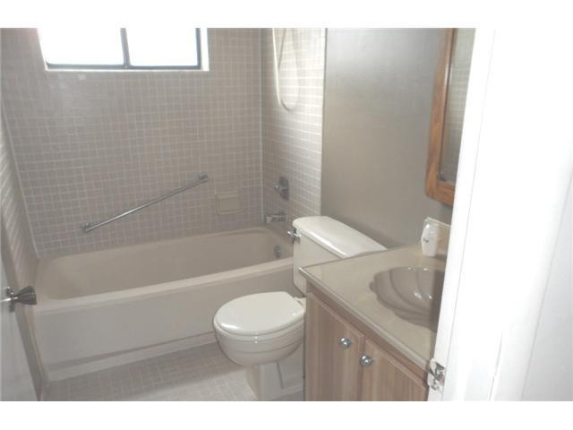 9920 Northwest 68th Place, Unit 210 Tamarac, FL 33321 - Photo 11 of 12 a bathroom with a granite countertop toilet a sink and bathtub