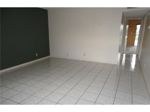 9920 Northwest 68th Place, Unit 210 Tamarac, FL 33321 - Photo 3 of 12 a view of an empty room and wooden floor