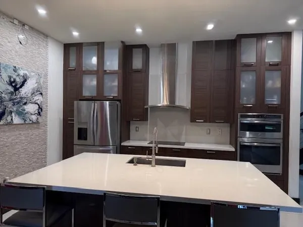 a kitchen with kitchen island a sink appliances and a counter top space
