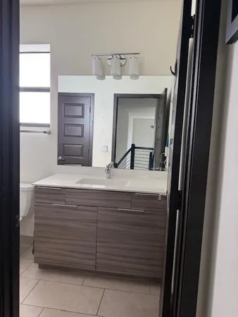 a bathroom with a granite countertop sink and mirror