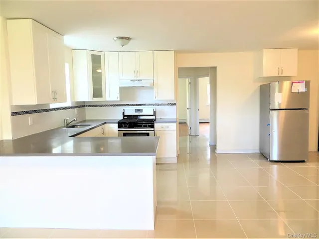 a kitchen with a refrigerator a stove a sink a counter top space and cabinets