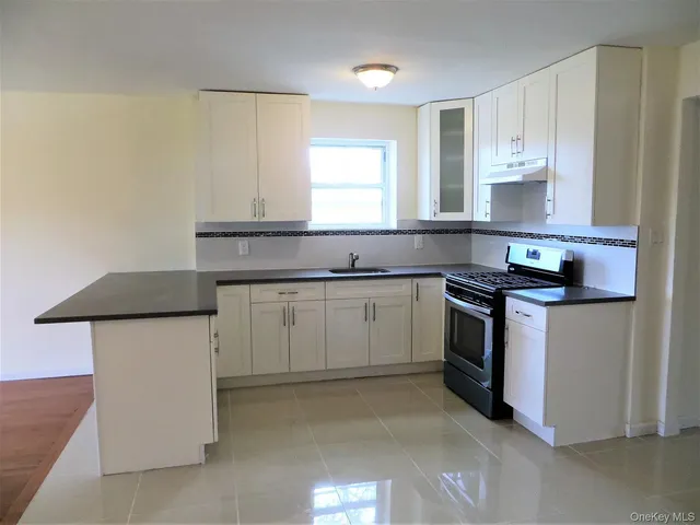a kitchen with granite countertop white cabinets and white appliances