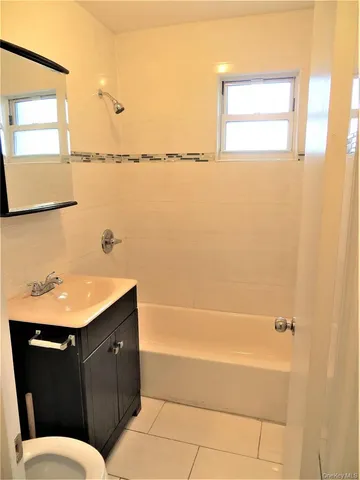 a bathroom with a granite countertop sink toilet and bathtub