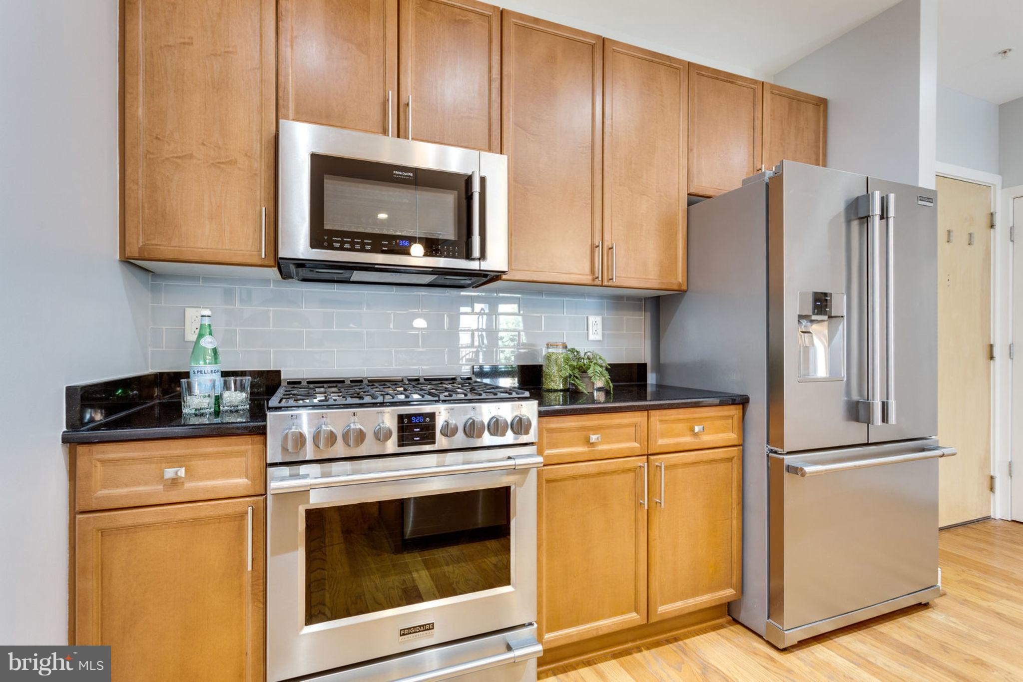 181 East Reed Avenue, Unit 109 Alexandria, VA 22305 - Photo 5 of 30 a kitchen with stainless steel appliances granite countertop a stove a refrigerator and a microwave