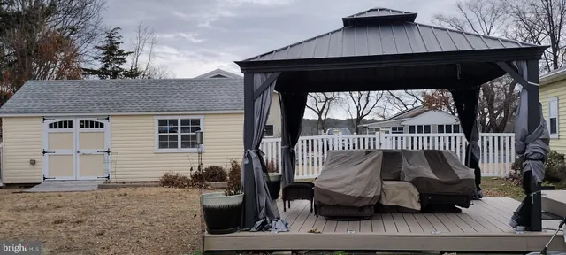 a view of a roof deck with couches and wooden fence