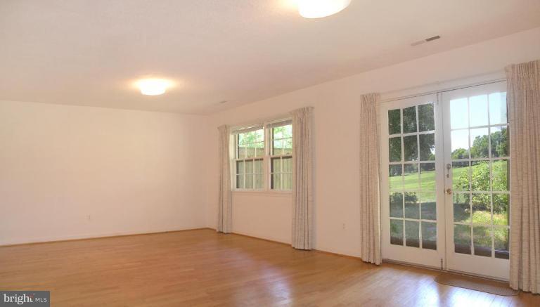 2074 Golf Course Drive Reston, VA 20191 - Photo 22 of 30 an empty room with wooden floor and windows