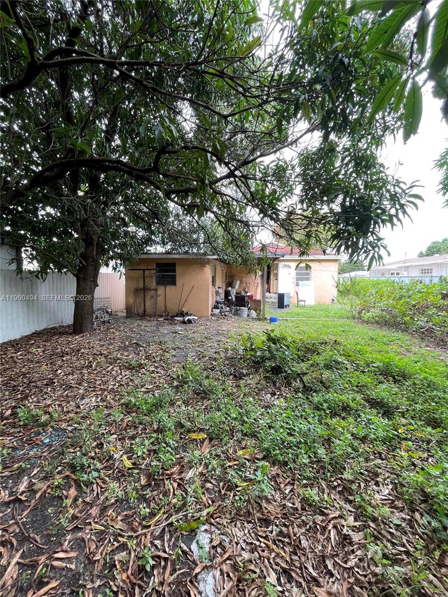 3630 Northwest 98th Street Miami, FL 33147 - Photo 28 of 38 a backyard of a house with lots of plants and large trees