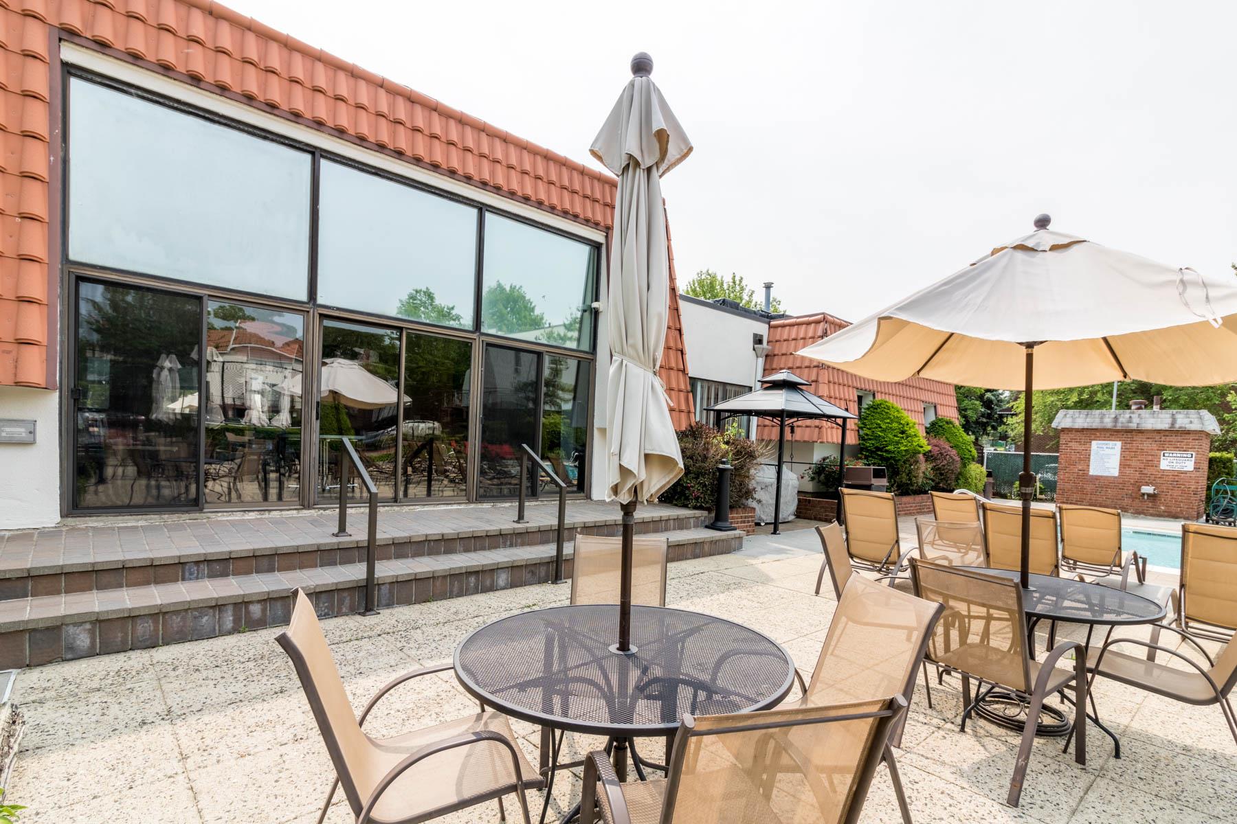 509 Julius Road Queens, NY 11356 - Photo 21 of 26 a patio with a table and chairs under an umbrella