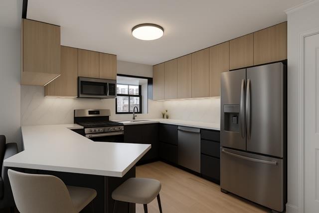 509 Julius Road Queens, NY 11356 - Photo 4 of 26 a kitchen with a refrigerator a stove a sink and chairs