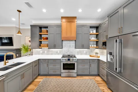 a kitchen with stainless steel appliances granite countertop a sink stove and refrigerator