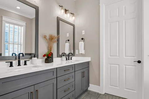 a bathroom with double sink and a mirror