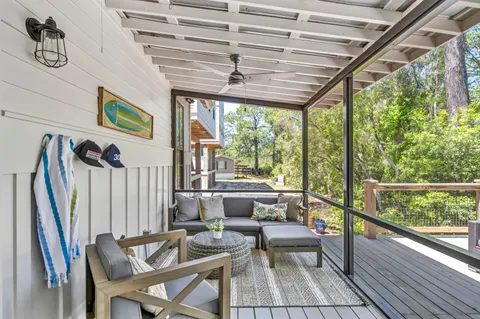 a dining room with furniture large windows and wooden floor