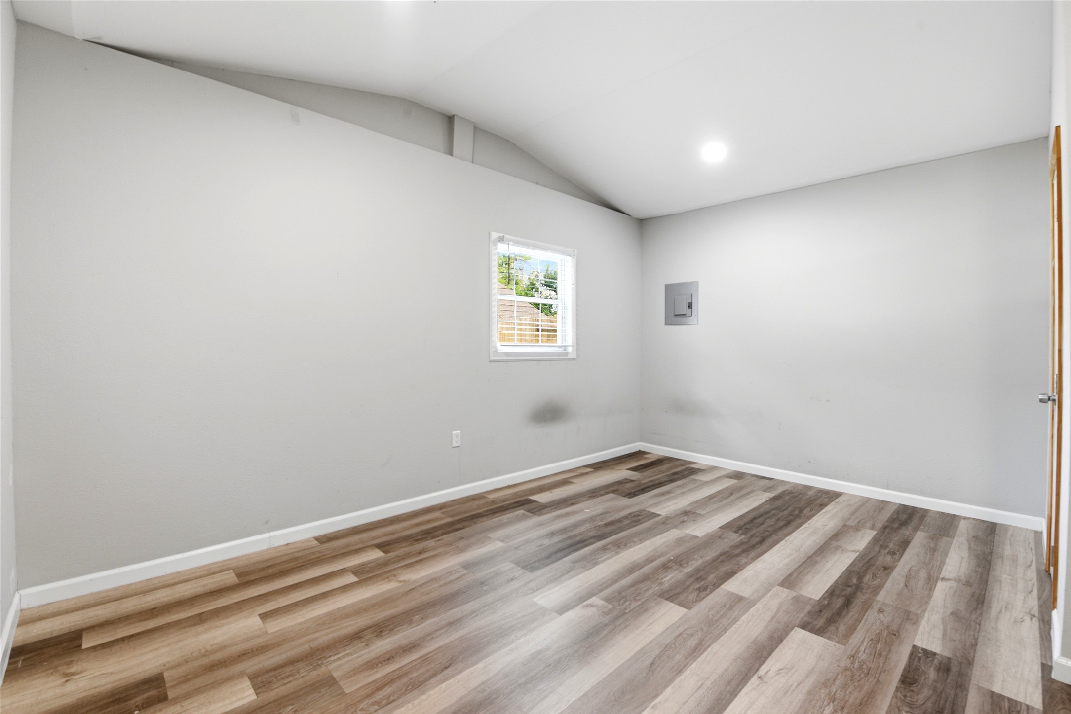 9403 Spaulding Street Houston, TX 77016 - Photo 41 of 50 This room features neutral-colored walls, a single window providing natural light, and modern wood-look flooring. The space is open and versatile, suitable for various uses.