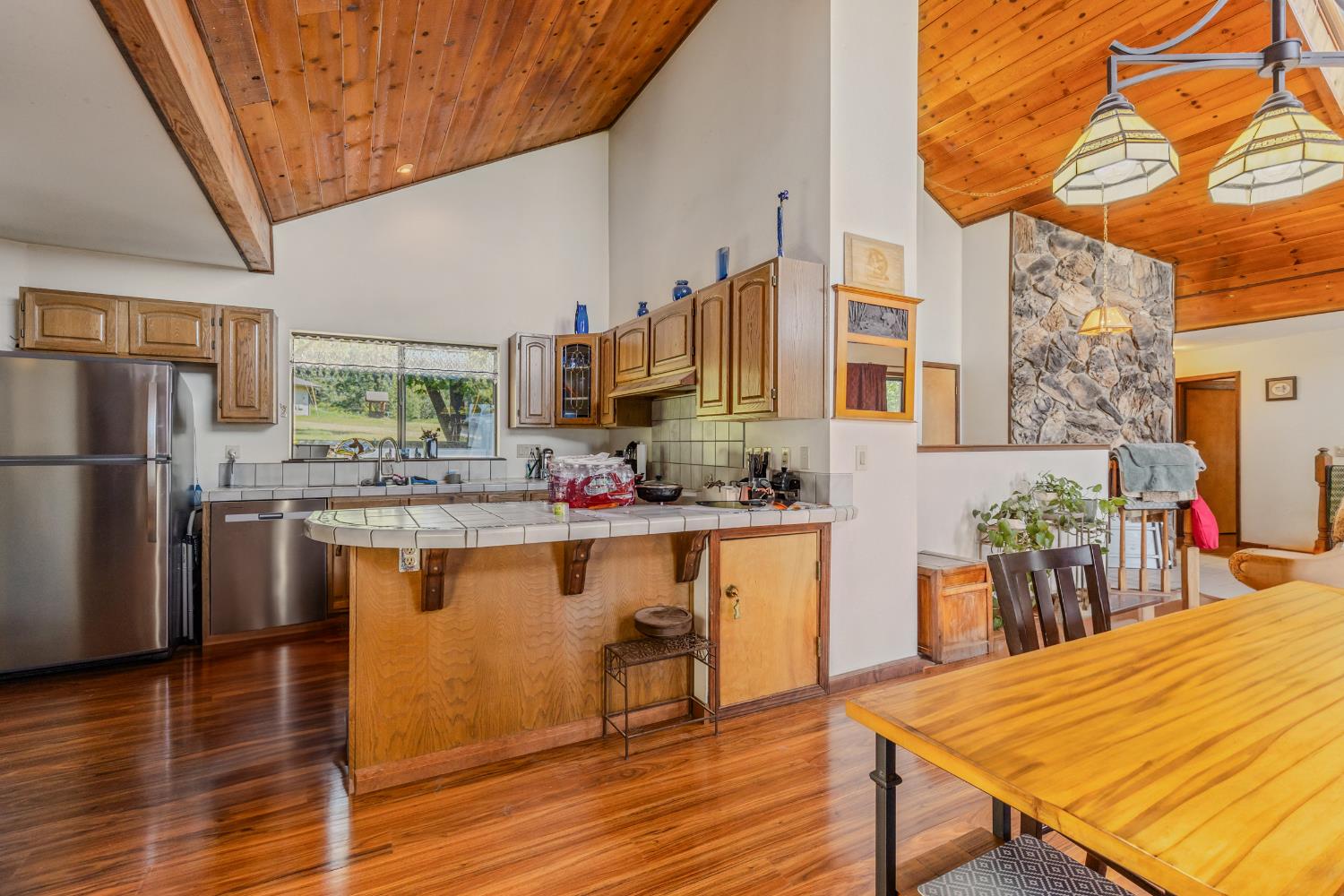 3120 Iron Mine Road Auburn, CA 95602 - Photo 8 of 38 a kitchen with stainless steel appliances kitchen island granite countertop a table chairs in it and wooden floors