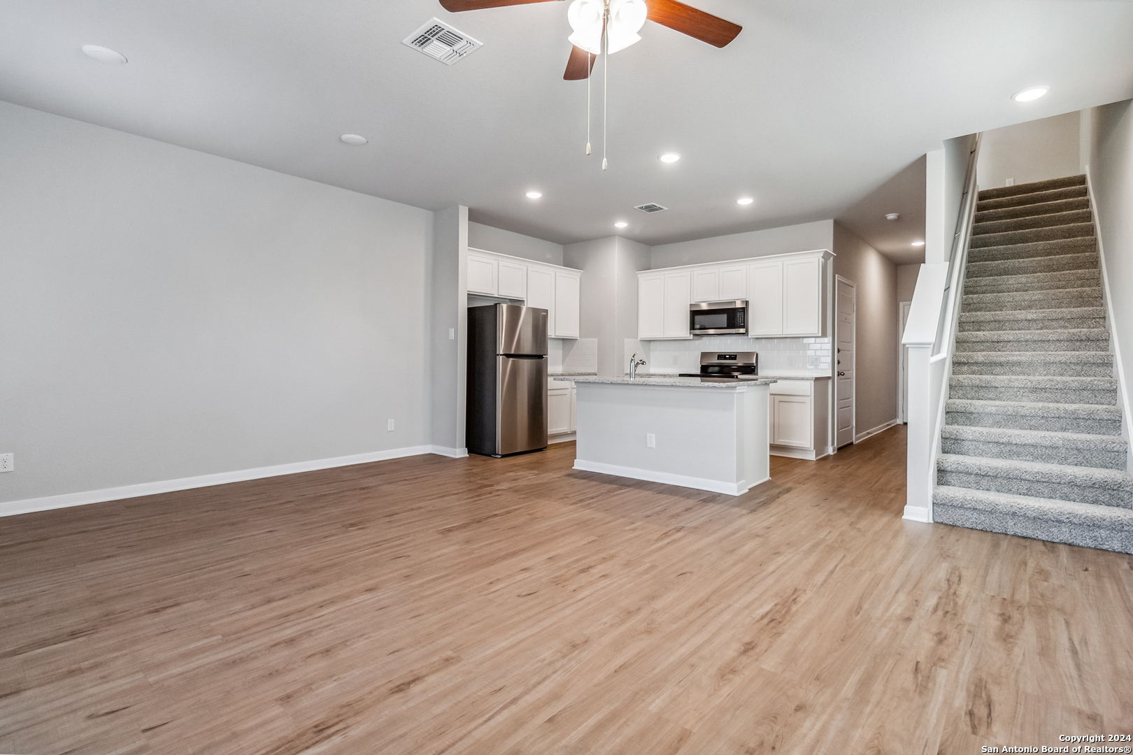 3915 Abbott Pass St. Hedwig, TX 78152 - Photo 2 of 35 a view of a kitchen with wooden floor and a ceiling fan