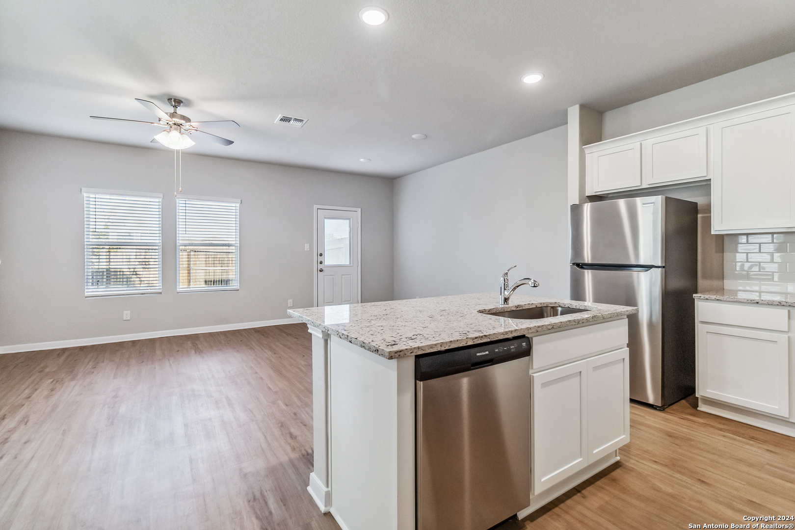 3915 Abbott Pass St. Hedwig, TX 78152 - Photo 7 of 35 a kitchen with stainless steel appliances granite countertop cabinets wooden floor and a refrigerator