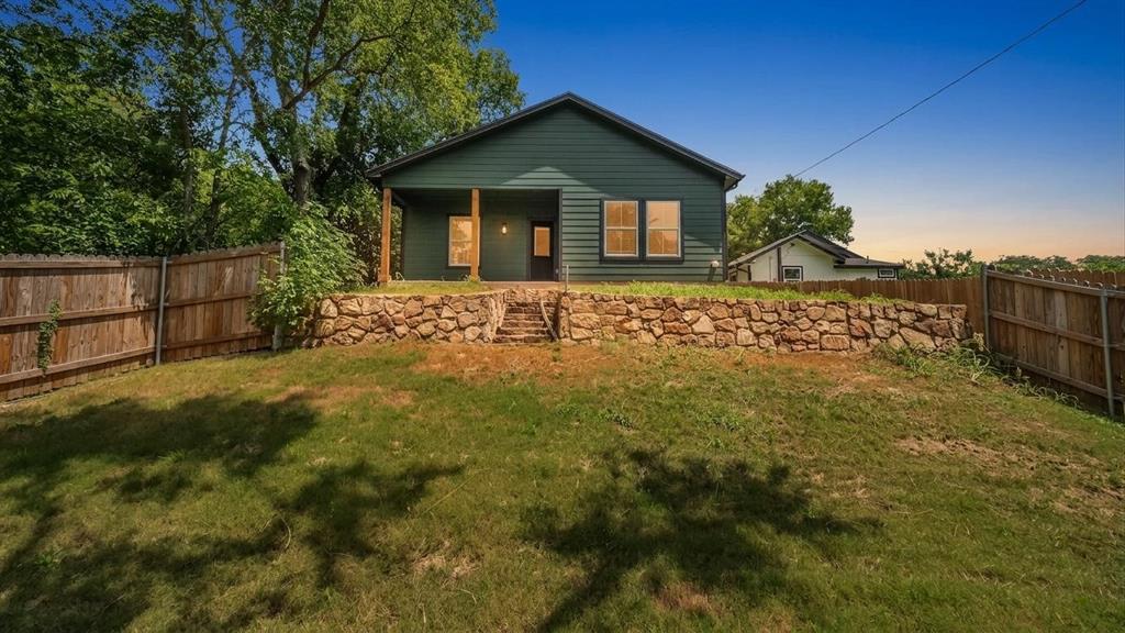 716 East Chestnut Street Denison, TX 75021 - Photo 3 of 26 Expansive backyard with a manicured lawn, framed by a wood privacy fence