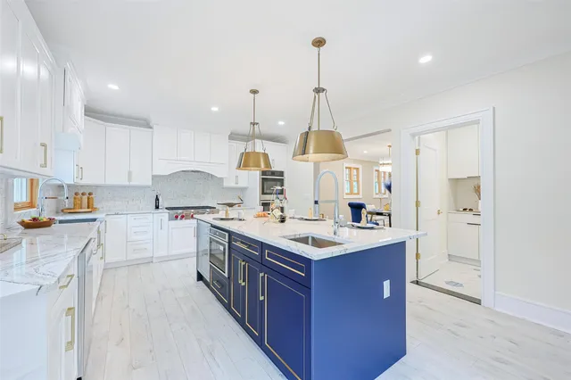 a kitchen with kitchen island a sink counter top space appliances and a window
