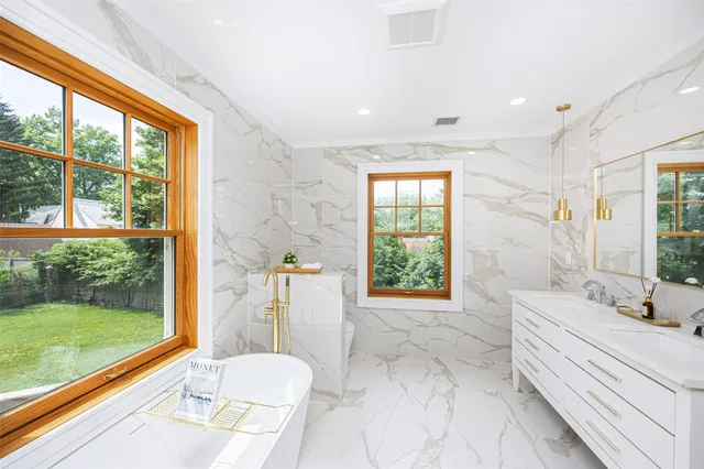 a bathroom with a sink a toilet a window and shower