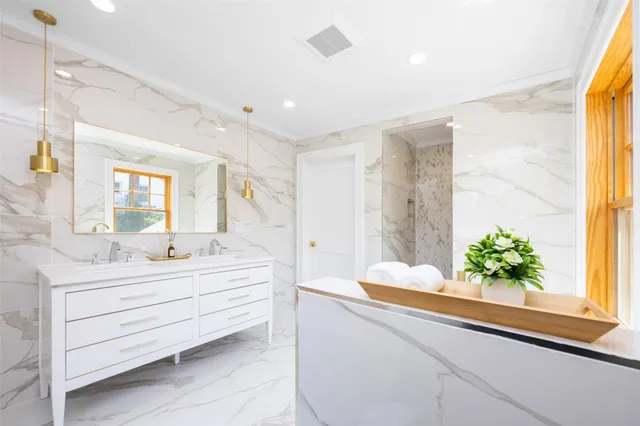 a bathroom with a granite countertop sink mirror and shower