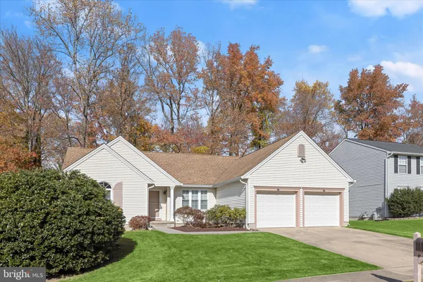 a front view of a house with a garden and plants
