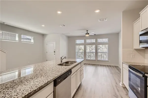 a kitchen with stainless steel appliances granite countertop a refrigerator stove and microwave