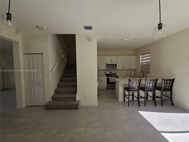 a kitchen with stainless steel appliances granite countertop a sink and a refrigerator