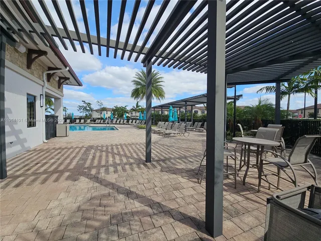 a view of a house with swimming pool and sitting area