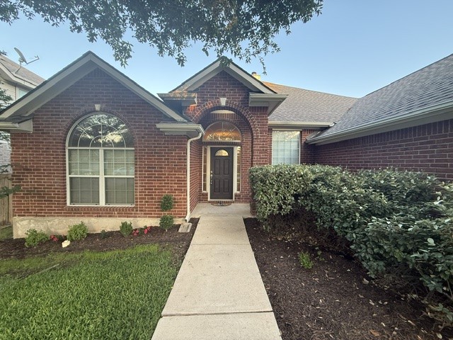 20724 Kearney Hill Road Pflugerville, TX 78660 - Photo 2 of 40 Brick facade residence featuring a covered entry, arched front door, and an arched window with white framing