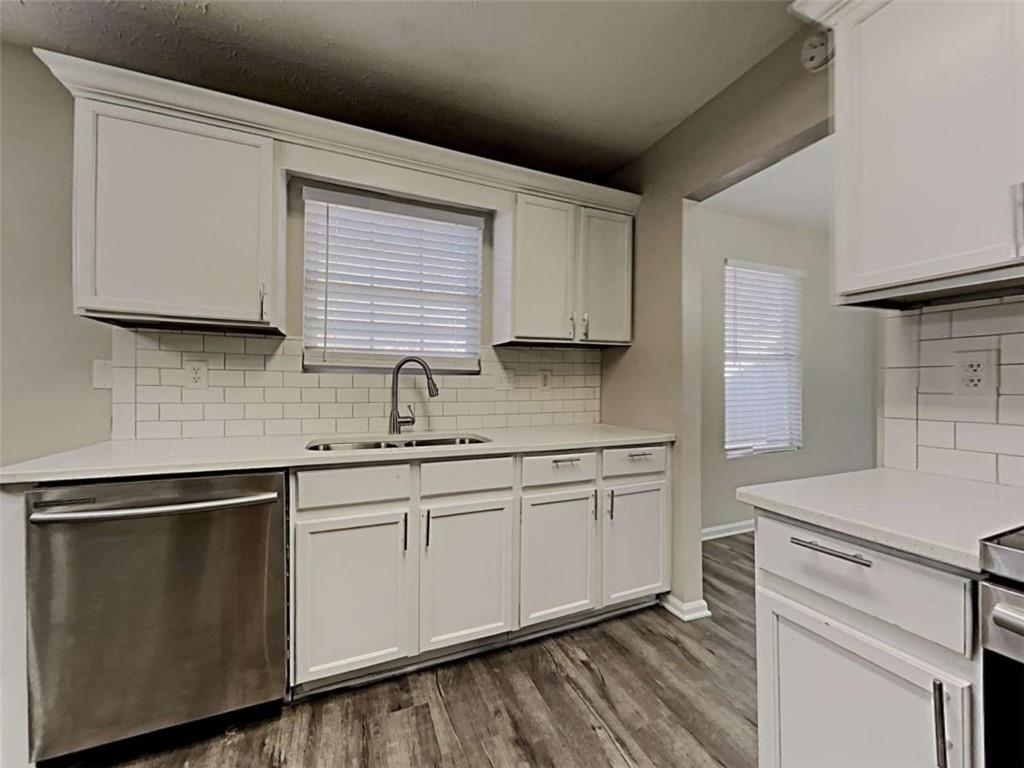 4856 Haymarket Trail Decatur, GA 30035 - Photo 7 of 23 a kitchen with granite countertop white cabinets sink and white stainless steel appliances