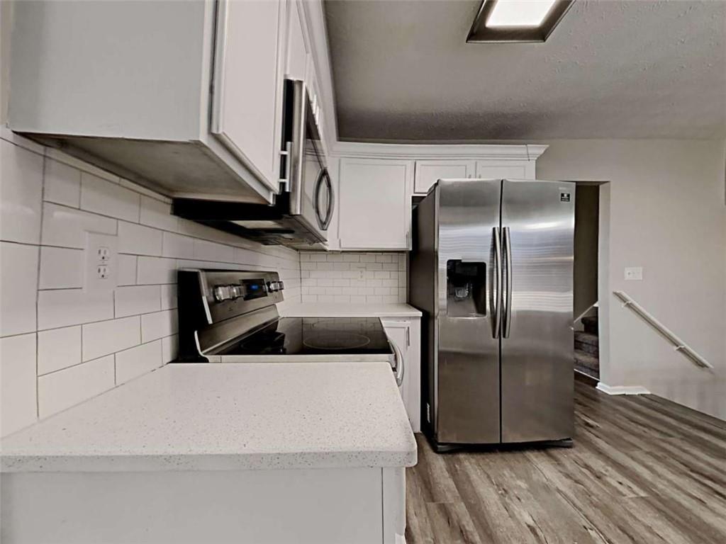 4856 Haymarket Trail Decatur, GA 30035 - Photo 8 of 23 a kitchen with stainless steel appliances a refrigerator and a hard wood floor
