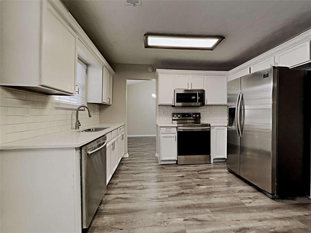 4856 Haymarket Trail Decatur, GA 30035 - Photo 9 of 23 a kitchen with granite countertop a refrigerator and a stove top oven