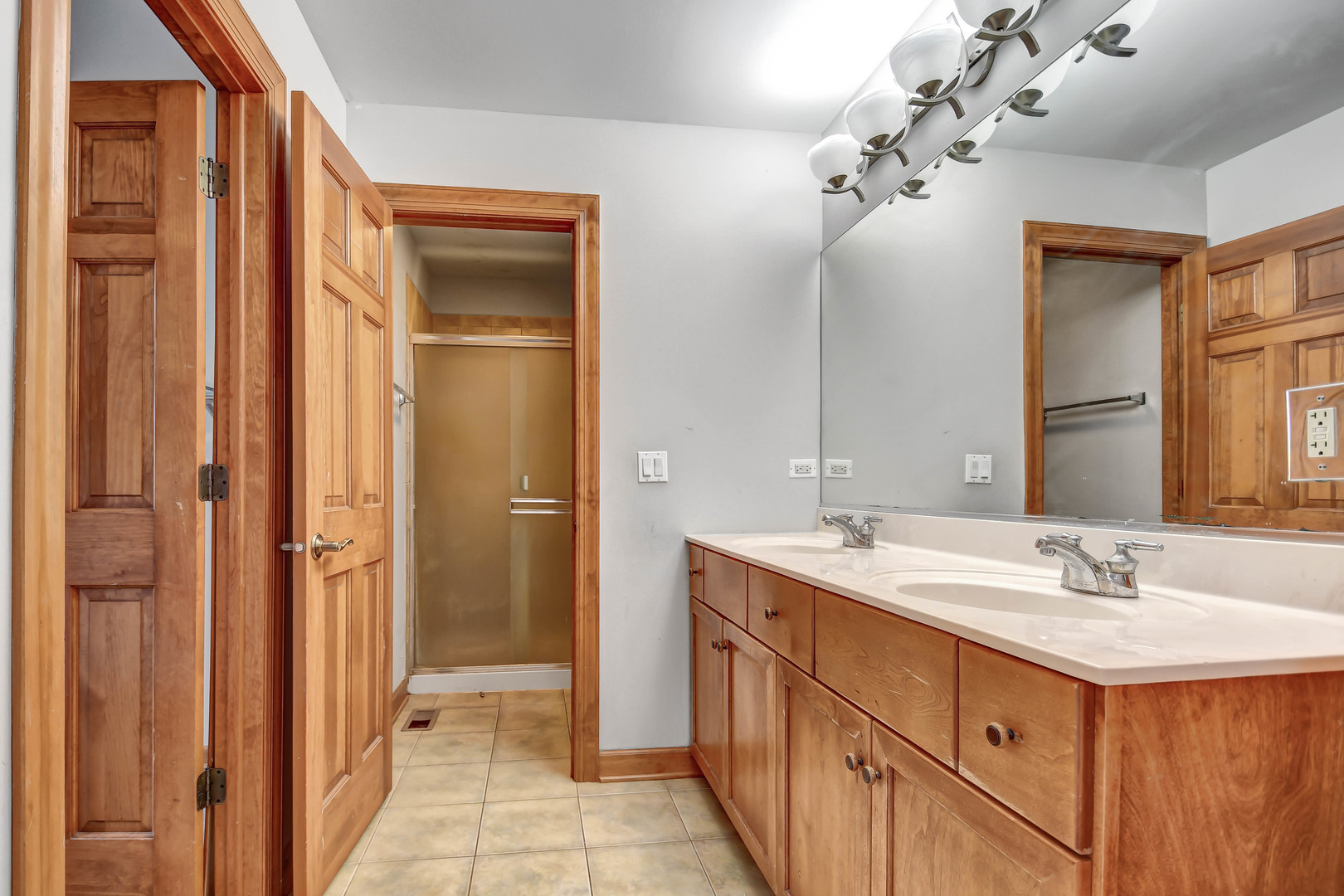 1S174 Addison Avenue Lombard, IL 60148 - Photo 20 of 37 a bathroom with a double vanity sink a mirror and a shower