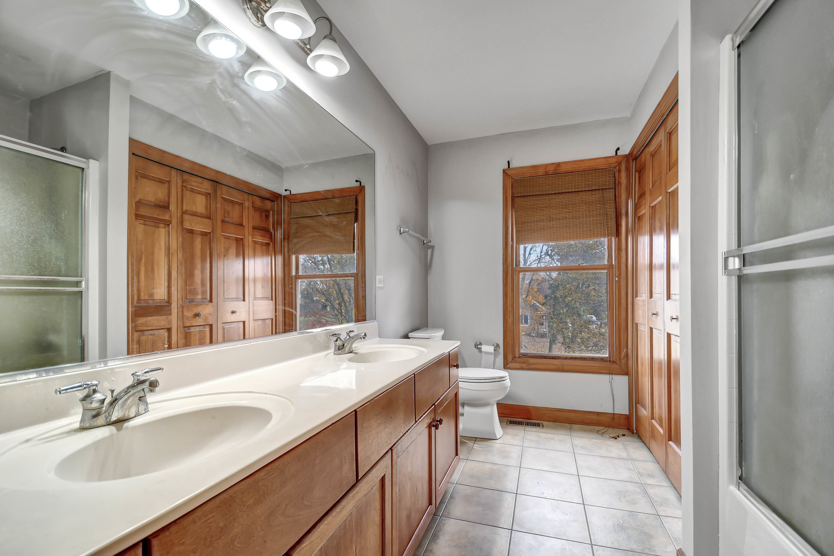 1S174 Addison Avenue Lombard, IL 60148 - Photo 26 of 37 a spacious bathroom with a double vanity sink a large mirror and a bathtub