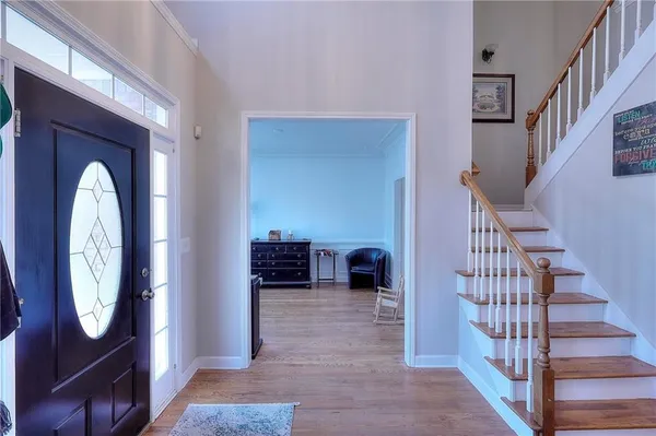 a view of a hallway with entryway wooden floor and a livingroom