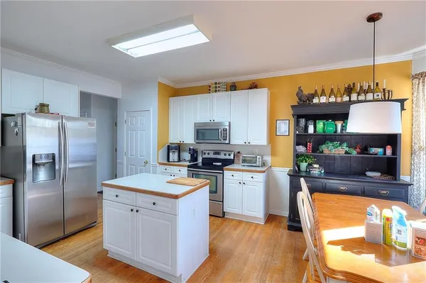 a kitchen with a stove a refrigerator and a fireplace