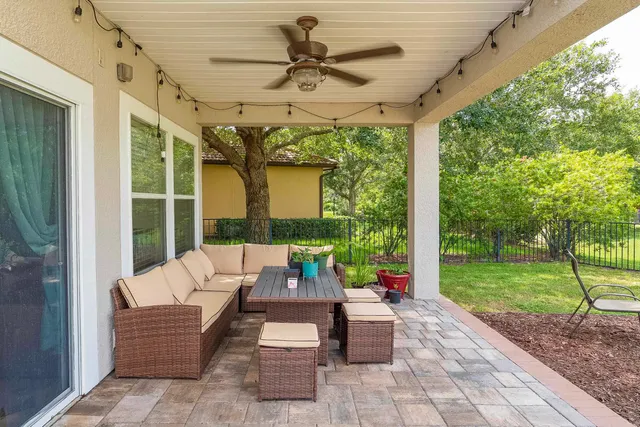 a view of a patio with table and chairs potted plants and a palm tree