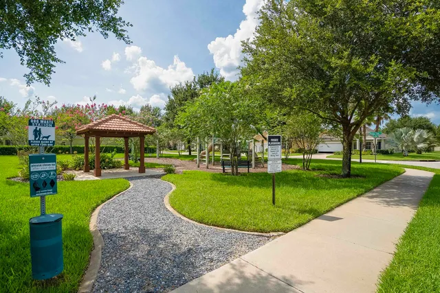 an aerial view of a house with a yard and trees all around