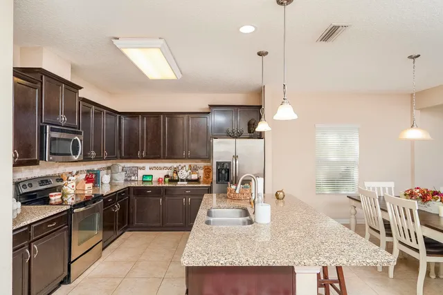 a kitchen with granite countertop a sink and a refrigerator