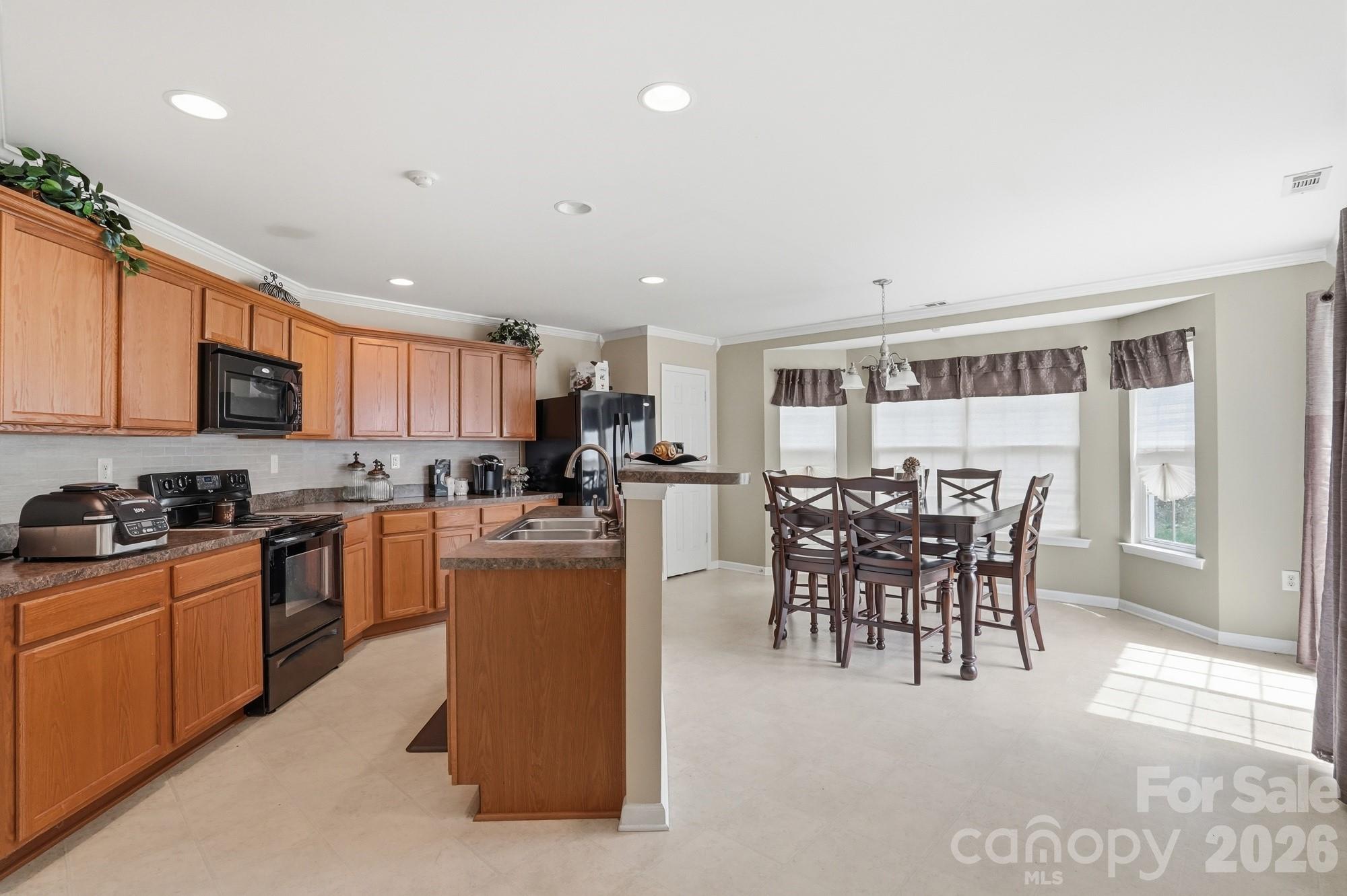 4404 Kiddle Lane Monroe, NC 28110 - Photo 12 of 48 a kitchen with microwave a dining table and chairs