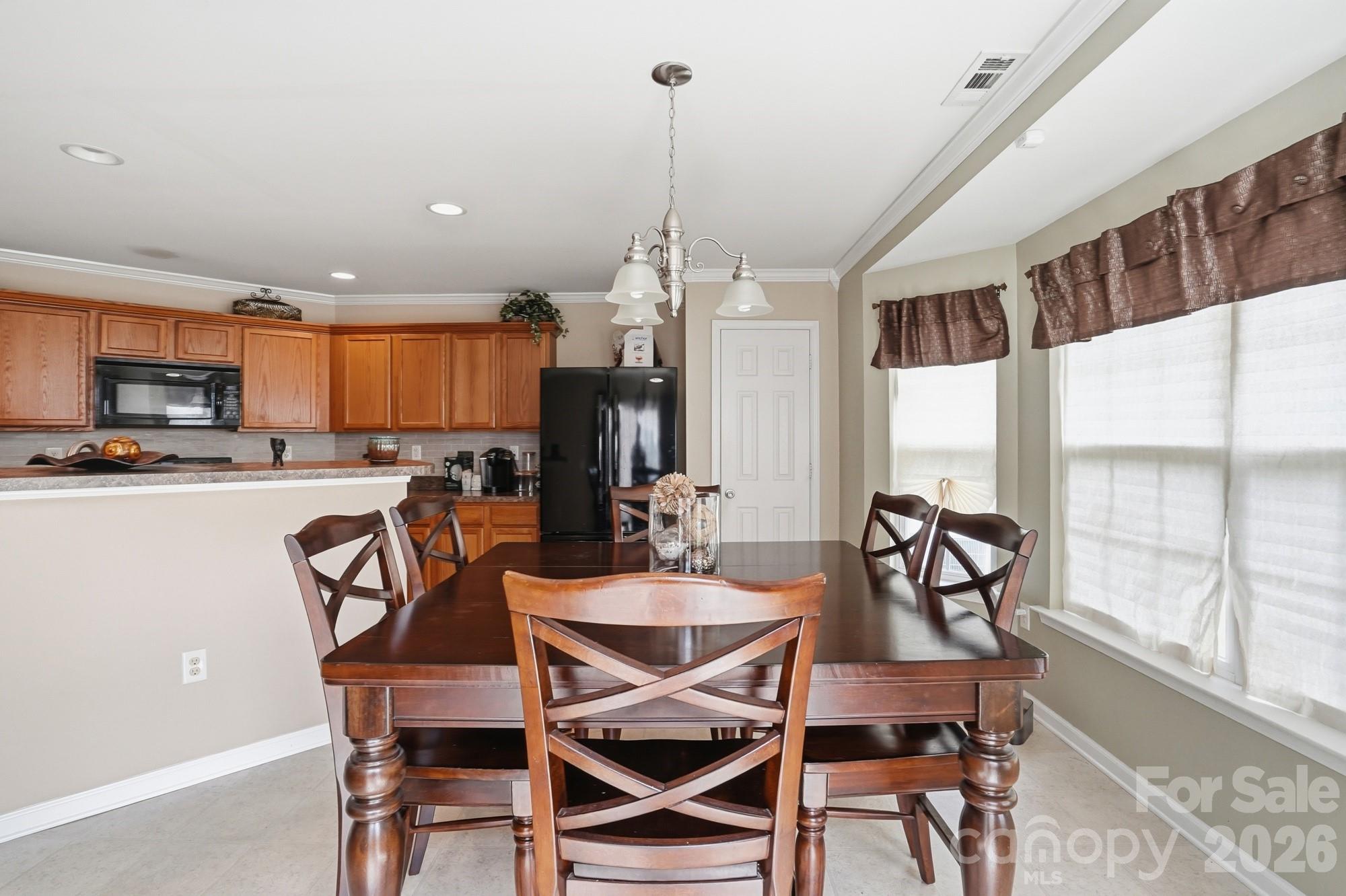 4404 Kiddle Lane Monroe, NC 28110 - Photo 21 of 48 a dining room with furniture a chandelier and kitchen view