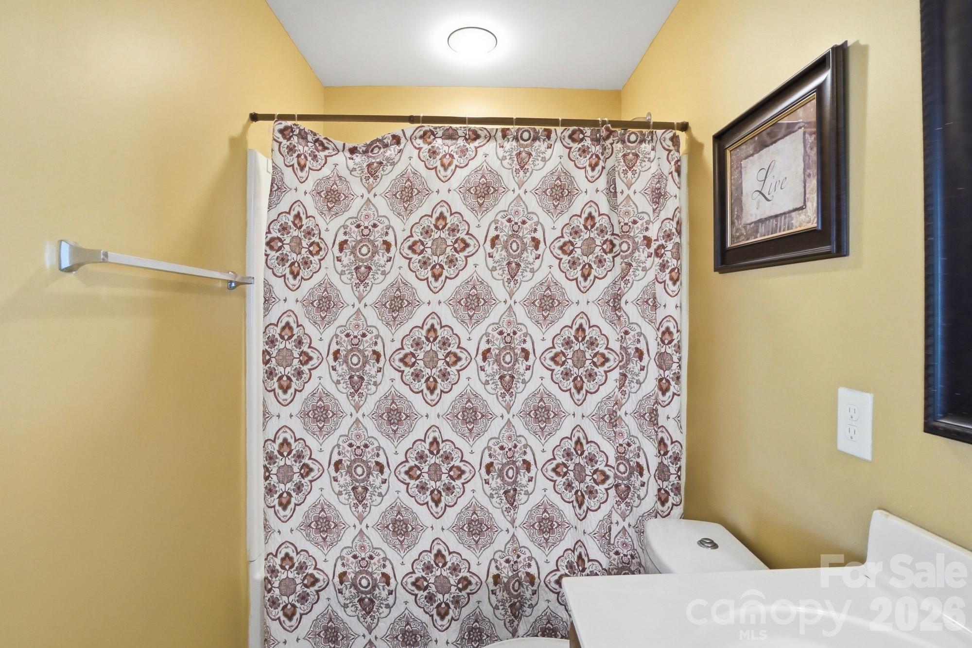 4404 Kiddle Lane Monroe, NC 28110 - Photo 32 of 48 a bathroom with a toilet and a shower curtain